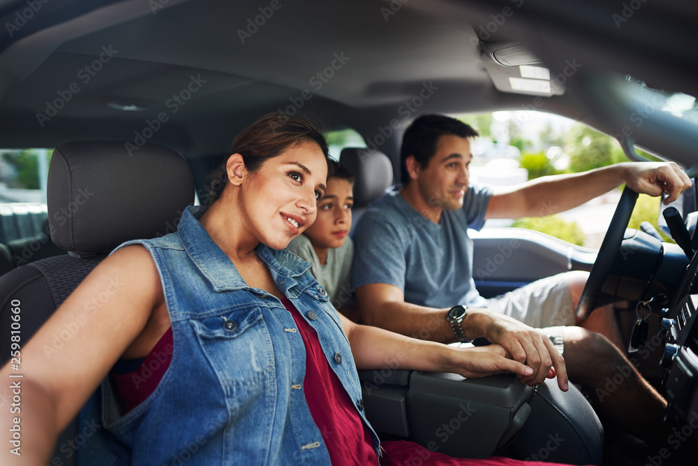hispanic family with mother, father and son sitting in truck looking outside hispanic family with mother, father and son sitting in truck looking outside