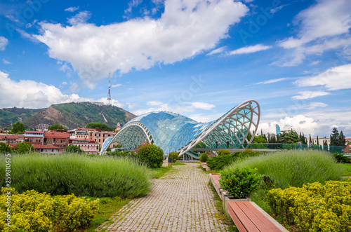 Modern glass Peace bridge in historical center of old Tbilisi, Georgia photo