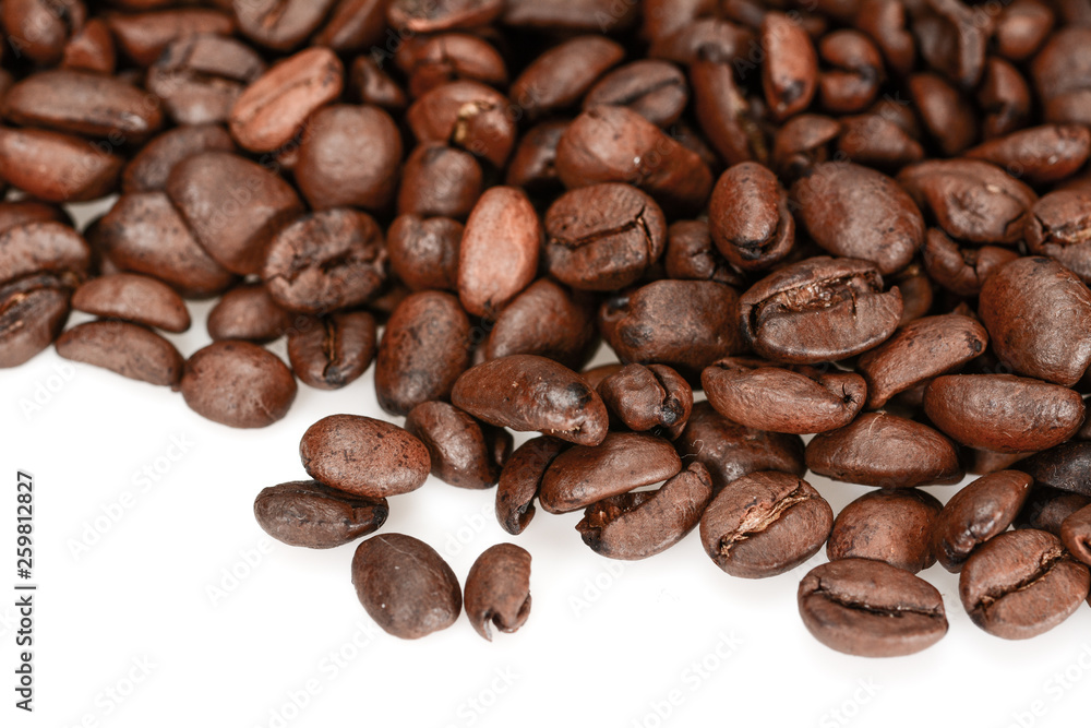 Roasted coffee beans, dark brown close up isolated on a white background Roasted coffee beans, dark brown close up isolated on a white background