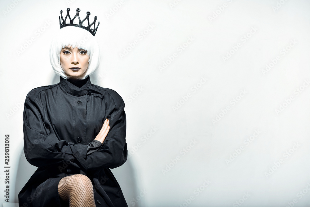 Black queen. A stern look. Black crown. A princess. Maleficent. Girl with a black  crown decorated with precious stones sitting in studio on light background.  Dark lipstick. Stock Photo | Adobe Stock