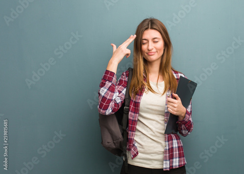 Young student russian woman doing a suicide gesture