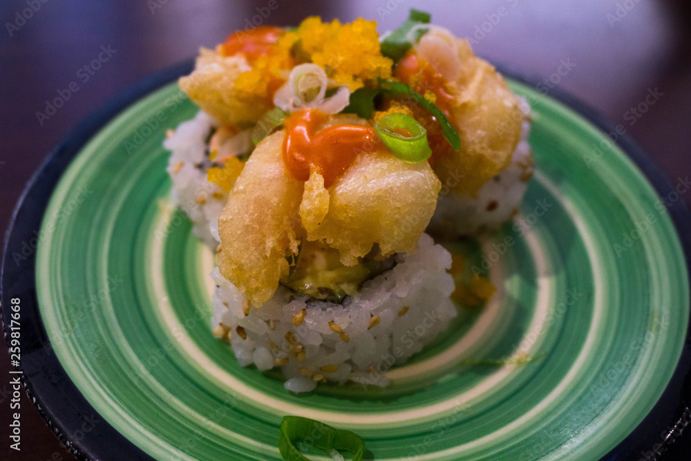 fried shrimp sushi roll on a green plate fried shrimp sushi roll on a green plate