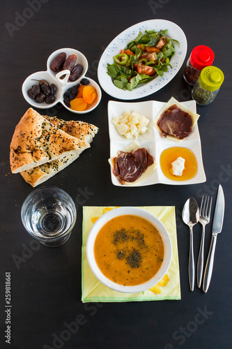 Traditional Ramadan Dinner Table  with symbolic foods on the black surface.Muslim worship of Ramadan.