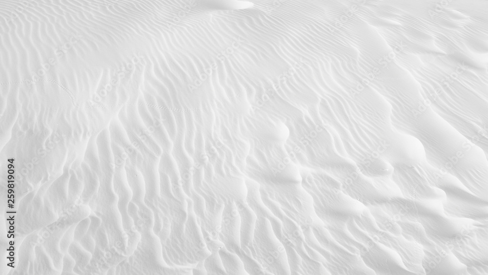 Obraz premium White sand texture background with wave pattern and insect trails 