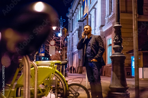 Young man talking on smart phone outdoor in the evening