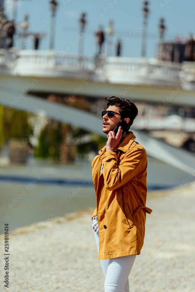 Business man making a call with his smartphone outside