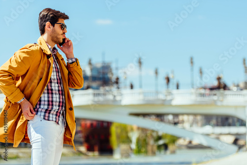 Modern businessman using mobile phone at urban place