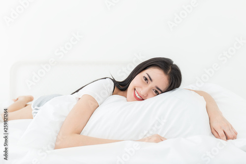 Tableau sur toile Portrait of beautiful young sexy asian woman with attractive smile enjoy fresh soft bedding linen and mattress in bed room modern apartment
