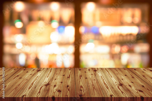 Empty wooden table top with blurred of coffee shop, cafe, bar background, Abstract background can be used for display or montage your products. photo
