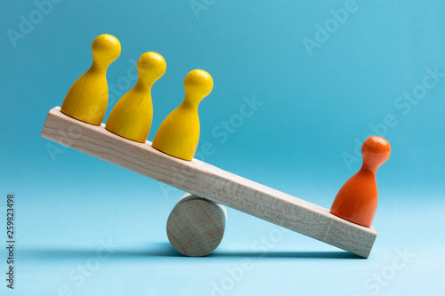 Fotografía Red And Yellow Pawns Figures Balancing On Wooden Seesaw