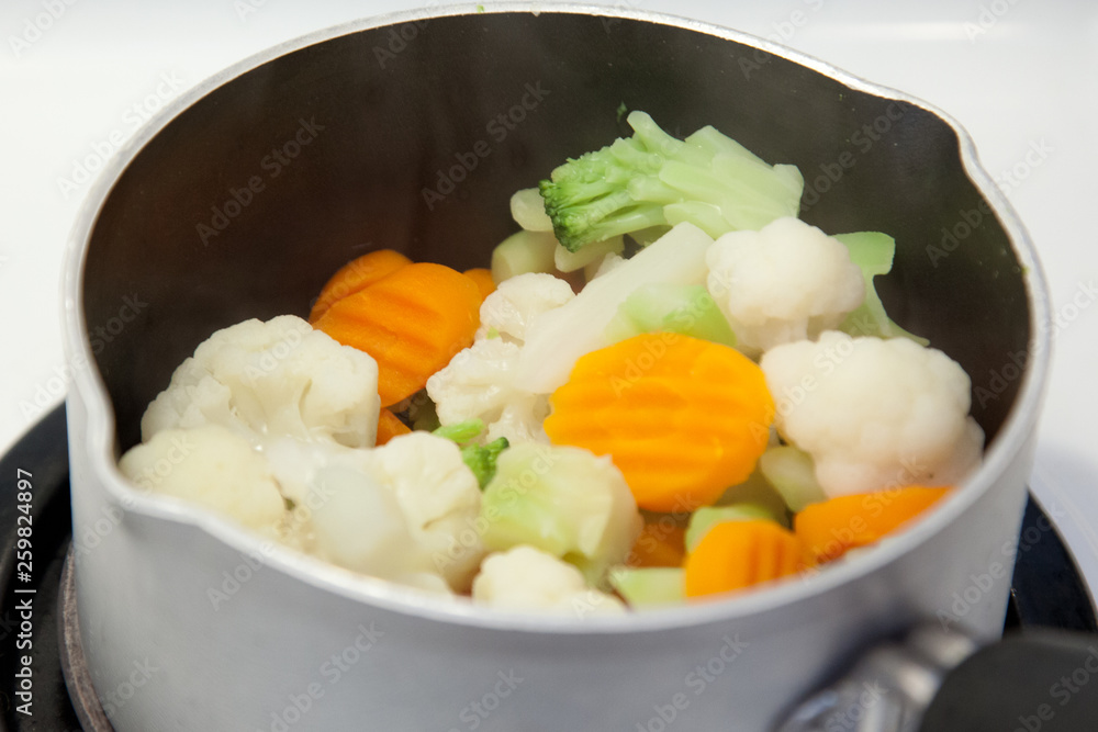 Frozen veggies in a small pot on top of the stove Frozen veggies in a small pot on top of the stove