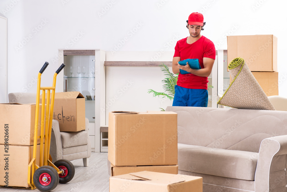 Young male contractor with boxes working indoors Young male contractor with boxes working indoors