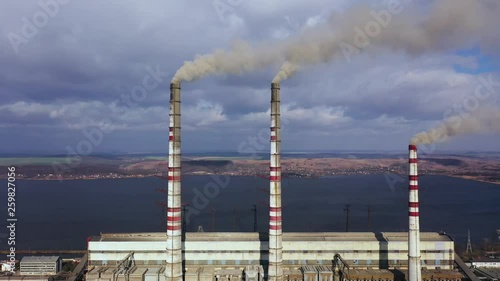 Aerial view of old thermoelectric plant with big chimneys in a rural landscape near the reservoir. Burshtyn, Ukraine photo