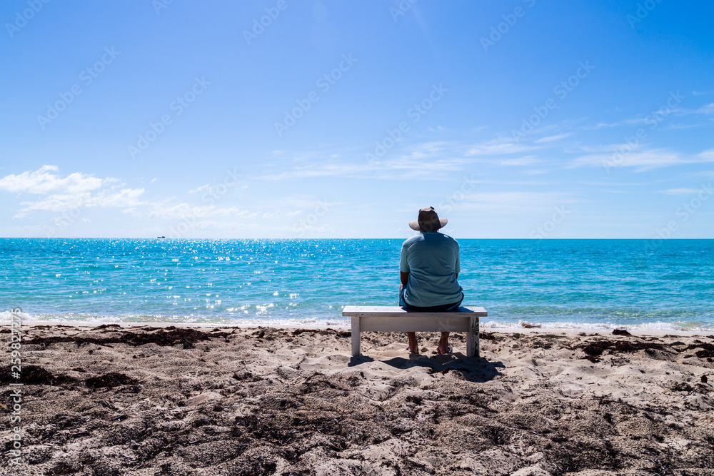 Man sitting on the bench at tropical beach. Man sitting on the bench at tropical beach.