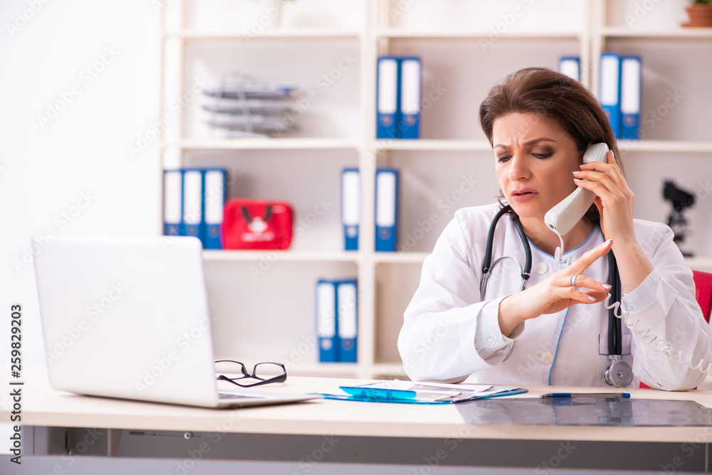 Aged female doctor working in the clinic Aged female doctor working in the clinic