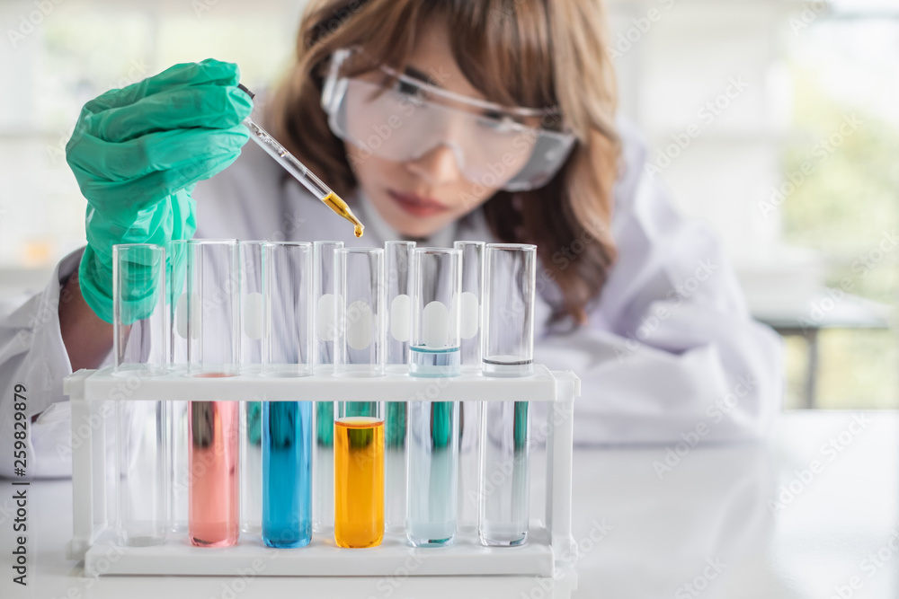 A young Asian woman scientist working in laboratory with test tube microscope and solutions. A young Asian woman scientist working in laboratory with test tube microscope and solutions.