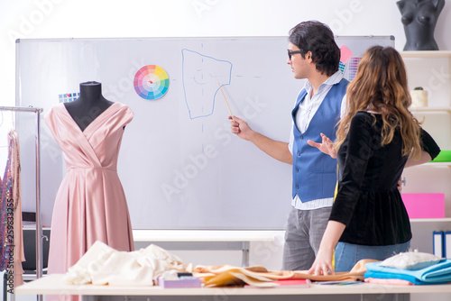 Young male tailor teaching female student 