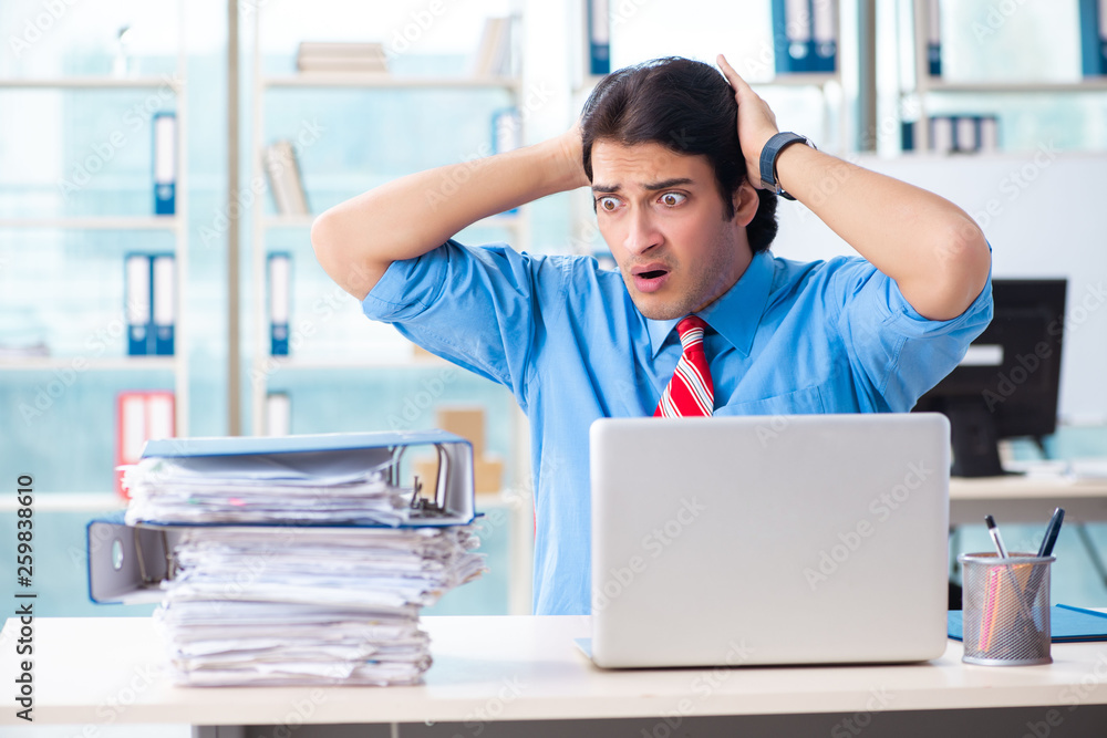 Handsome businessman unhappy with excessive work in the office Handsome businessman unhappy with excessive work in the office