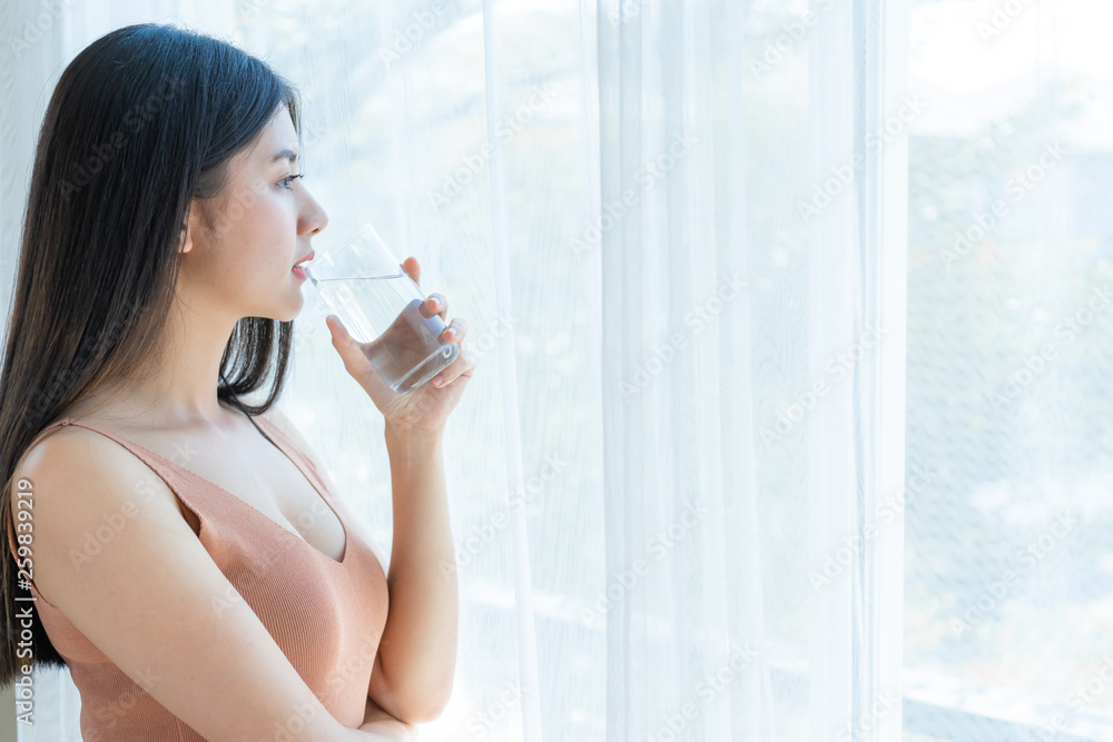 Beautiful beauty woman Asian cute girl feel happy drinking Clean drink water for good health in the morning , enjoying time in her home white bedroom background - lifestyle beauty woman concept Beautiful beauty woman Asian cute girl feel happy drinking Clean drink water for good health in the morning , enjoying time in her home white bedroom background - lifestyle beauty woman concept