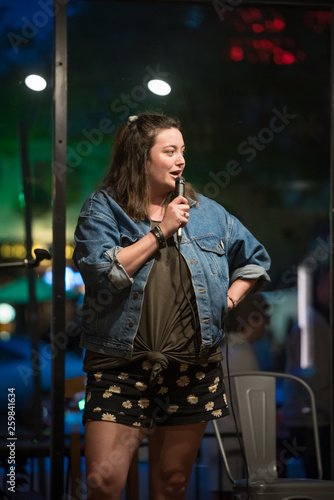 Wall Mural Talented female comedian performs her stand up at a local night spot open mic in