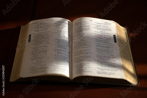 Open bible on a dark wood table