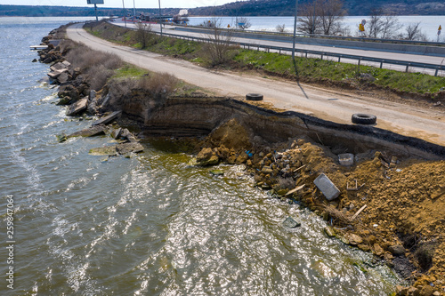 After an earthquake and strong storm in winter and severe destructive frost, asphalt road on landslide swept into sea. Closed road Destroyed asphalt road along sea. Broken asphalt crack and landslides