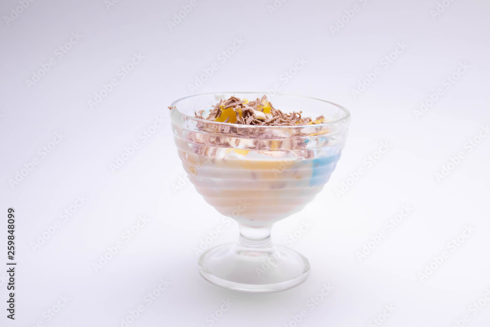 tasty homemade dessert in a sundae with colorful ice cream, fruit, chocolate chips on a white background for children and adults. tasty homemade dessert in a sundae with colorful ice cream, fruit, chocolate chips on a white background for children and adults.