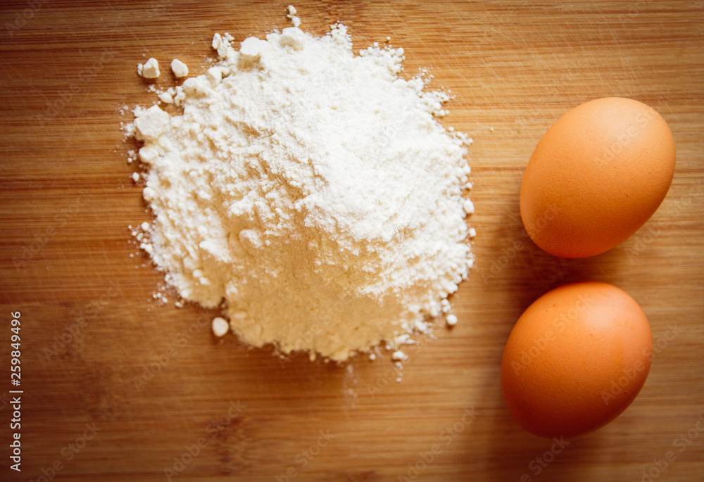 eggs and flour on a wooden board eggs and flour on a wooden board