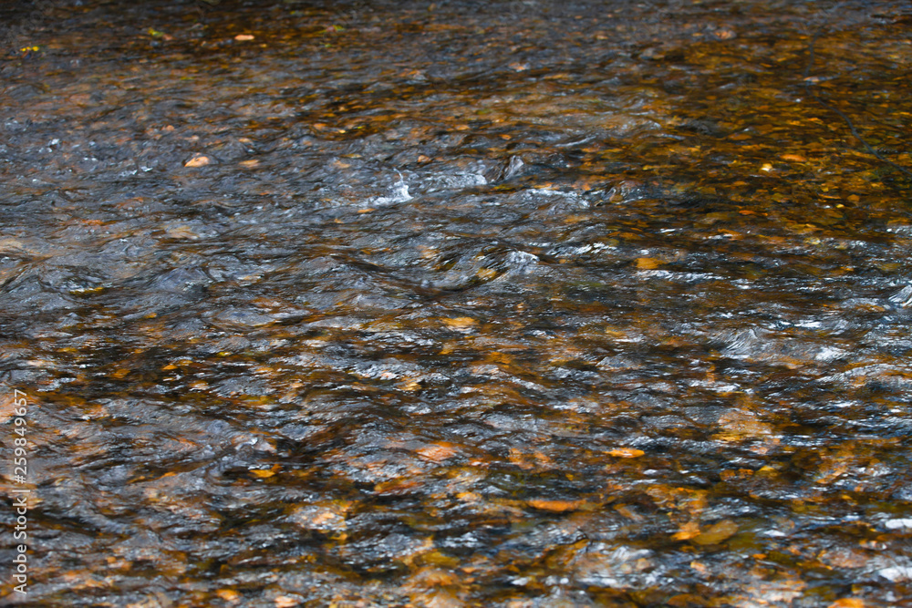 The reflection of the water surface with natural brown stones on the bottom is a lot of background.soft focus.