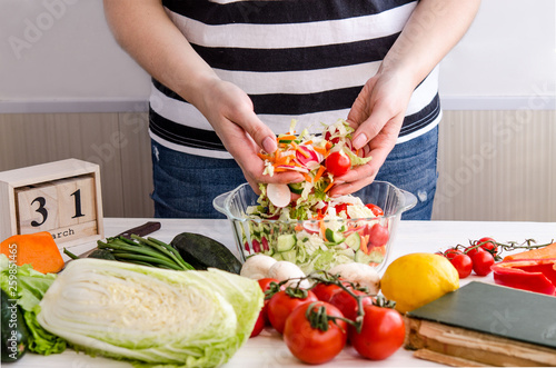 Woman hands adding vegetables to dishes