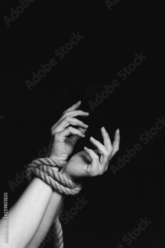 tied hands on black background