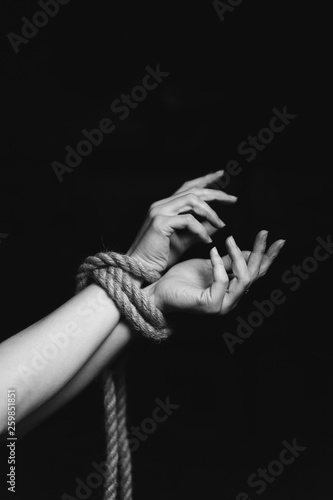 tied hands on black background