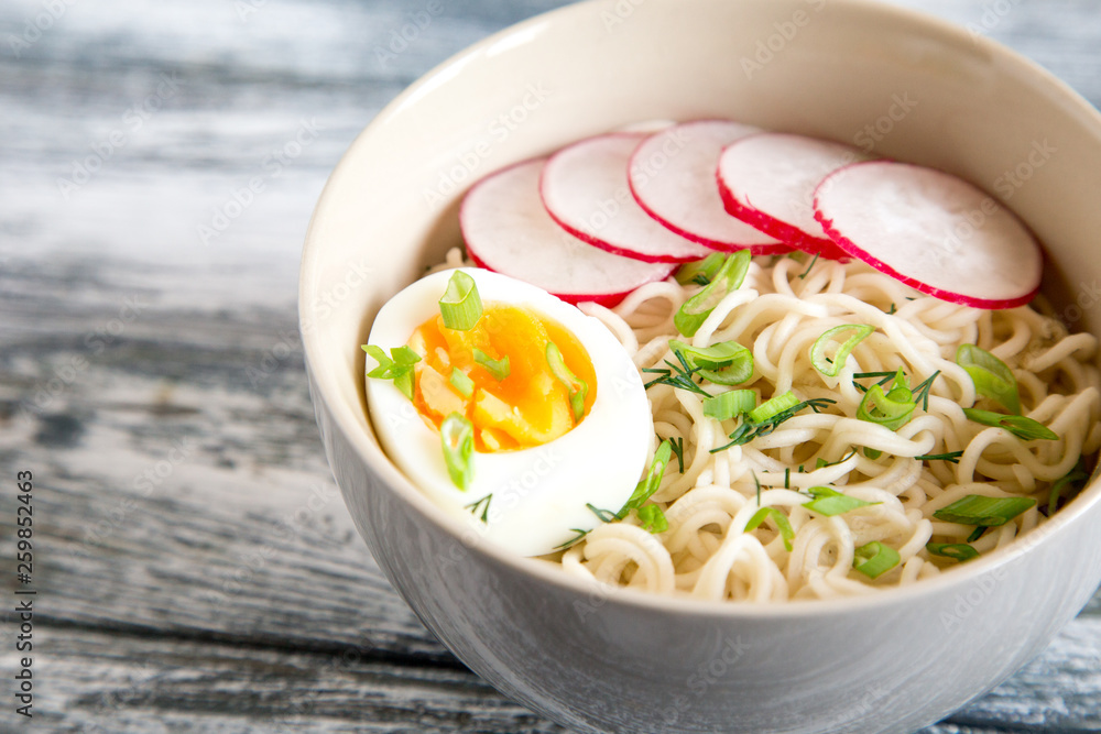 Instant noodles on wooden background. Cooked chinese instant noodles. Soup Ramen with egg and radish. Instant noodles on wooden background. Cooked chinese instant noodles. Soup Ramen with egg and radish.