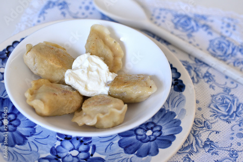 Dumplings pierogi on a plate with sour cream