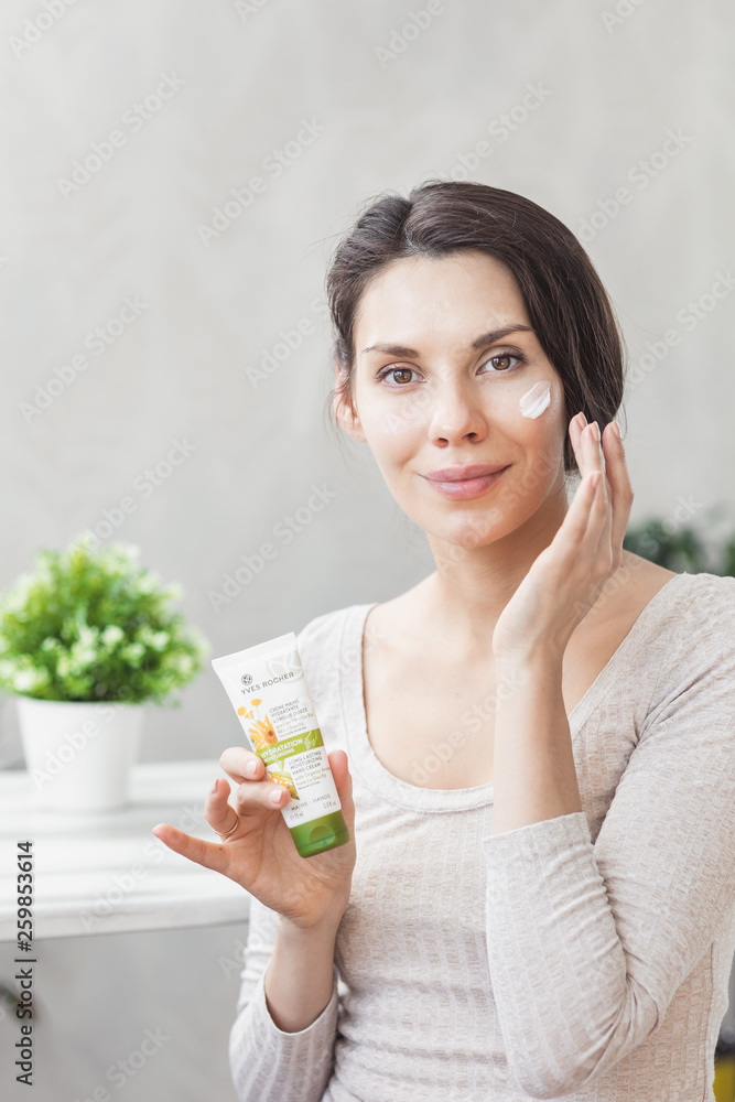 Portrait Of Beautiful Young Woman with Natural Makeup applying white Under Eye Patches Beauty Mask On Face. Girl with eye patches. Woman with collagen pads under her eyes Portrait Of Beautiful Young Woman with Natural Makeup applying white Under Eye Patches Beauty Mask On Face. Girl with eye patches. Woman with collagen pads under her eyes