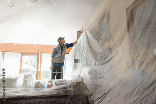 House painter painting the interior of a furnished house