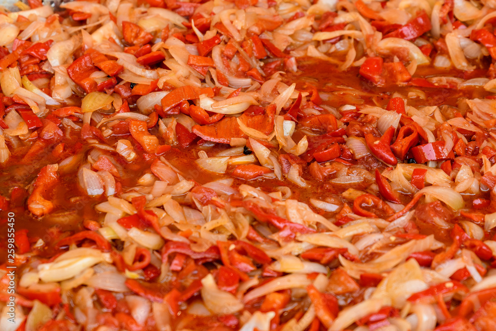 Clouse up of many fresh cut red peppers and onions boiling for a vegetable soup Clouse up of many fresh cut red peppers and onions boiling for a vegetable soup