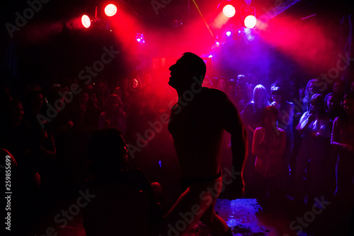 silhouette of a male stripper performing on stage photo