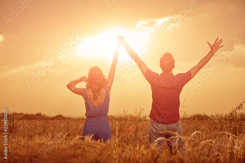 Couple in sunset / sunrise time in a wheat field.