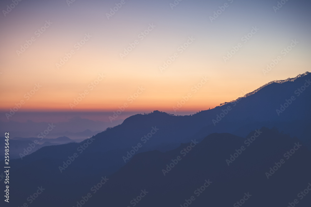 Bright stunning amazing sunset dawn in the mountains of Sri Lanka, the sun rises from behind the mountains. Beautiful minimalistic landscape