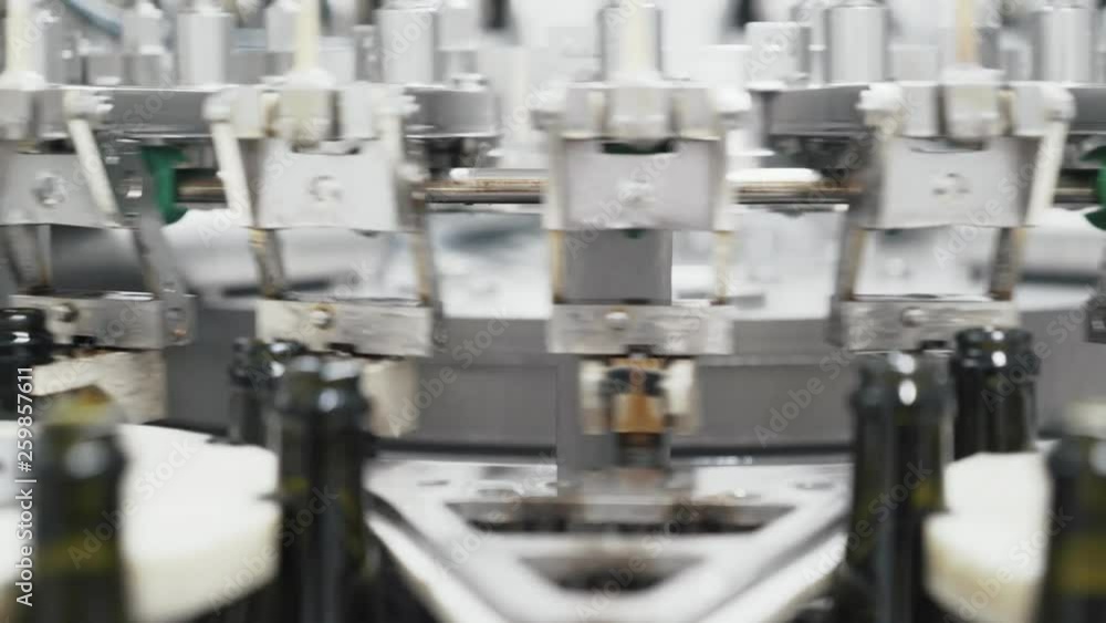 Glass bottles on the automatic conveyor line at the champagne or wine factory. Plant for bottling alcoholic beverages. Glass bottles on the automatic conveyor line at the champagne or wine factory. Plant for bottling alcoholic beverages.