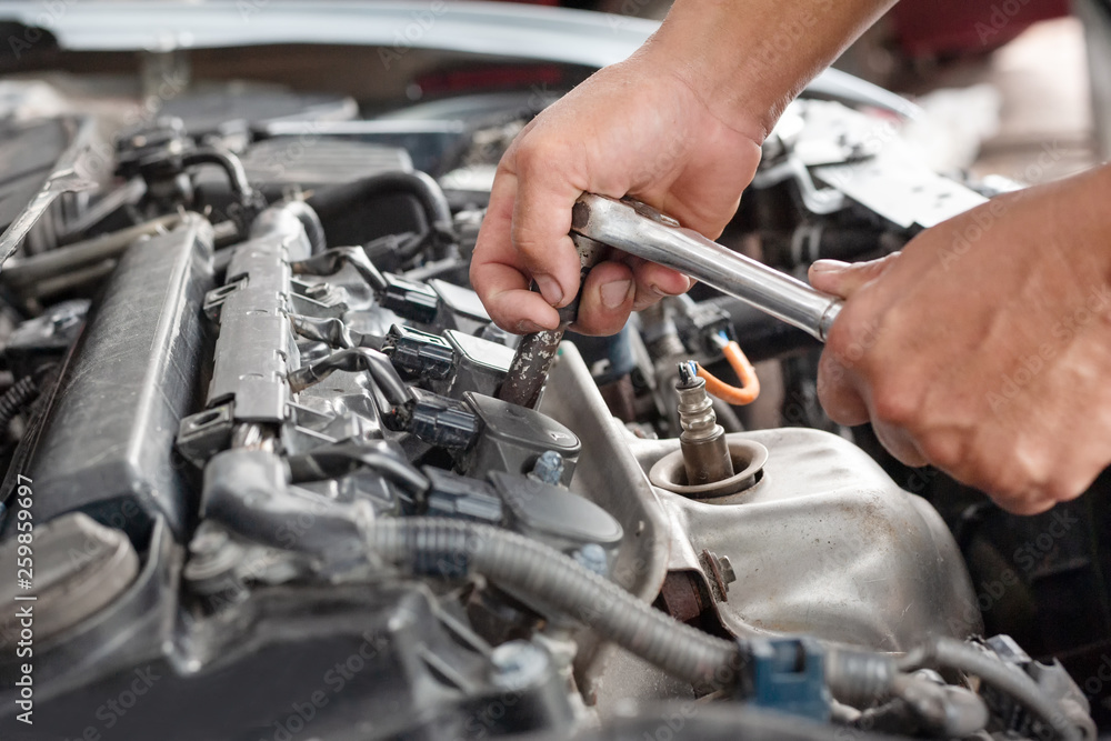 Hands of mechanic working in auto repair shop Hands of mechanic working in auto repair shop