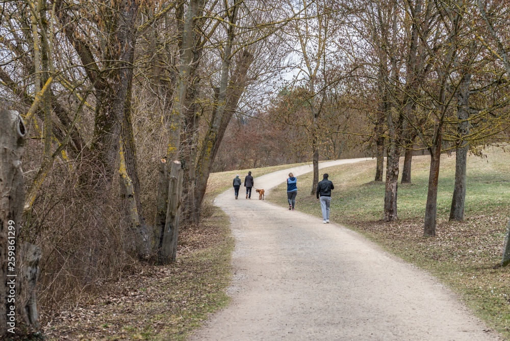 Spaziergänger in einem Park im Frühling, Deutschland
