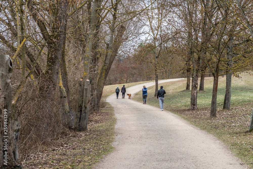 Spaziergänger in einem Park im Frühling, Deutschland Spaziergänger in einem Park im Frühling, Deutschland