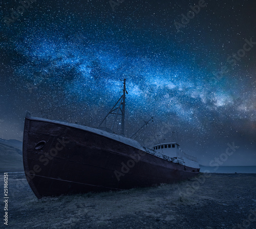 Fotografie Shipwreck on the shore and milky way in Iceland