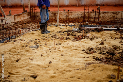 Construction worker is using compacted soil compactor.