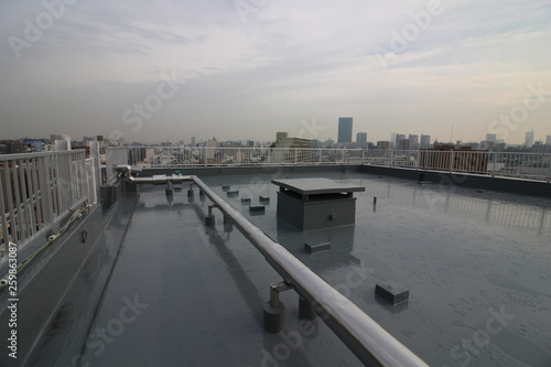 Fotografie 雨の後の屋上のウレタン塗膜防水と都心の眺め