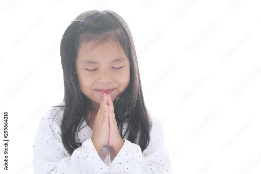 Asian child smiling hand in hand or kid girl pay obeisance and pray close eye or hello welcome and thank you with wear white shirt in morning at church or temple for peace on white background isolated Asian child smiling hand in hand or kid girl pay obeisance and pray close eye or hello welcome and thank you with wear white shirt in morning at church or temple for peace on white background isolated