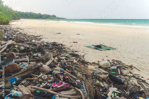 Beach pollution. Plastic bottles and other trash on sea beach photo