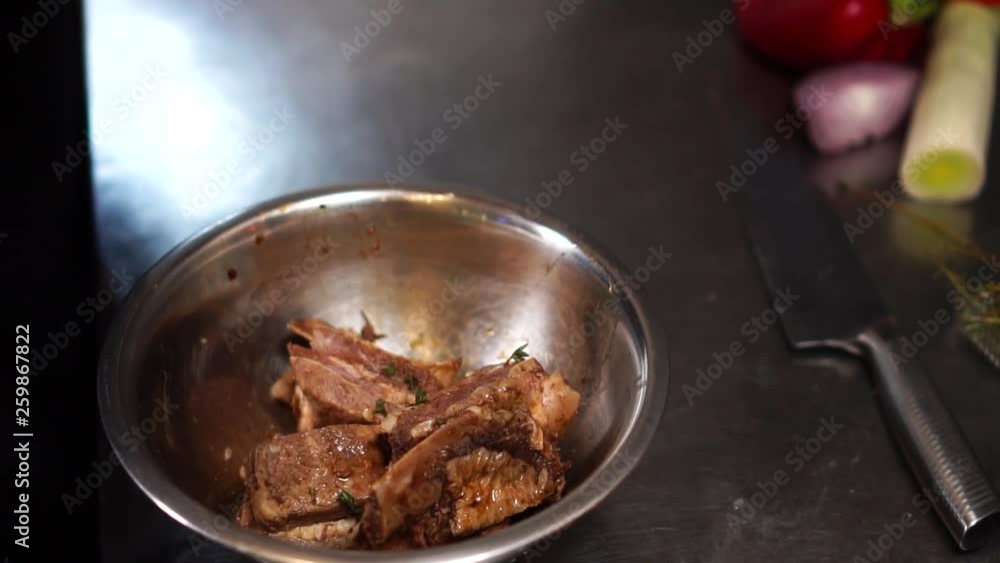 Detailed close up slow motion shot of raw beef meat in delicious spicy sauce in mixing bowl Detailed close up slow motion shot of raw beef meat in delicious spicy sauce in mixing bowl